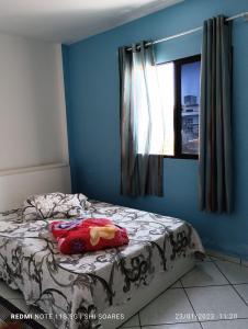 Ce lit se trouve dans une chambre bleue dotée d'une fenêtre. dans l'établissement Pousada Brisamar Morro dos Conventos, à Conventos