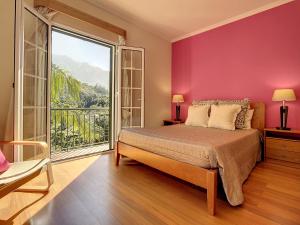 a bedroom with a bed and a large window at Mountain View Villa by Atlantic Holiday in São Vicente
