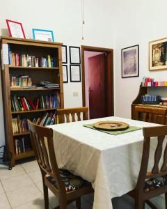 una mesa con 2 sillas y una estantería con libros en Il Giardino Nel Parco R&B, en Bolonia