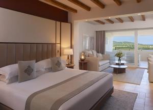 a bedroom with a large bed and a living room at Conrad Chia Laguna Sardinia in Chia +37 photos