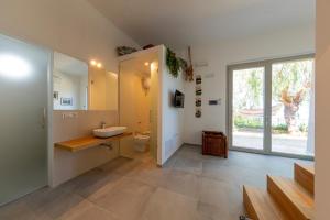 Un baño con lavabo, inodoro y ventana. en Loft Bacco, en Cefalú 11 fotos más
