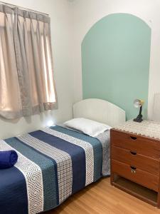 a bedroom with two beds and a dresser and a window at Hermoso departamento en pueblo libre cerca al aeropuerto in Lima