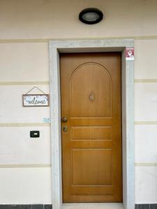 a brown door on a house with a sign on it at Green Room Del Garda in Castelnuovo del Garda