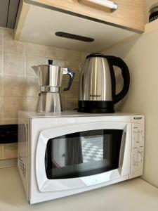 a microwave with a coffee pot on top of it at Green Room Del Garda in Castelnuovo del Garda