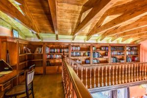 a library with book shelves and a wooden ceiling at Casa del Trotamundos in Villamayor de Campos