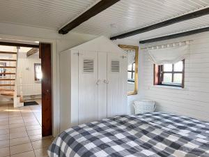 une chambre avec un lit avec une couverture à carreaux dans l'établissement Reetkate Reetdachhaus Friesen Chalet, à Tating