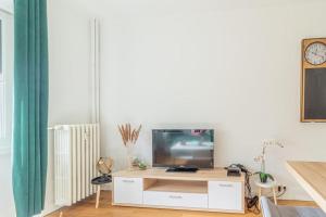 a living room with a television on a white cabinet at ZenBNB / Safari / 3 Personnes / 5 secondes du Tram in Ambilly