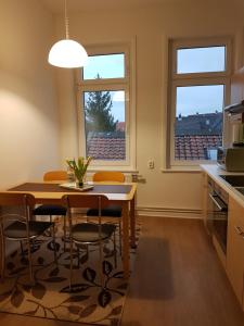 Una cocina y un comedor con una mesa y dos ventanas. en Brockenferien, en Bad Harzburg