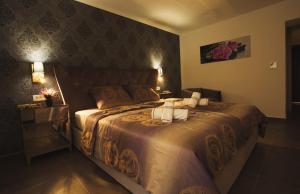 a bedroom with a large bed with two towels on it at Azzurro Luxury Rooms Trogir in Trogir