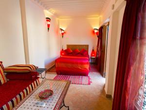 a bedroom with a red bed and a couch at Riyad Al Atik in Fez