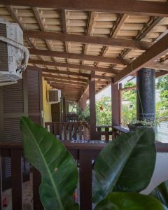 a patio with a wooden ceiling and a table with plants at Pousada Boliche in Palhoça