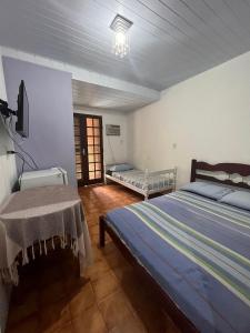 ein Schlafzimmer mit einem Bett und einem Tisch darin in der Unterkunft Pousada Boliche in Palhoça