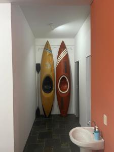 zwei Surfbretter, die im Bad gegen eine Wand lehnen in der Unterkunft Pousada Boliche in Palhoça