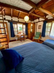 a bedroom with a blue bed and a desk at Casa Magnolia in Cumbayá