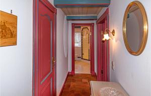 a hallway with a red door and a mirror at 2 Bedroom Lovely Apartment In Dagebll in Dagebüll