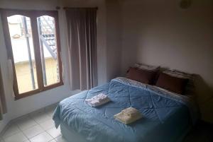 1 dormitorio con 1 cama azul y 2 toallas en Ushuaia Torre Los Navegantes, departamento1, 2hab. en Ushuaia