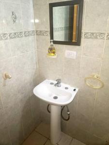y baño con lavabo blanco y espejo. en Ushuaia Torre Los Navegantes, departamento1, 2hab. en Ushuaia