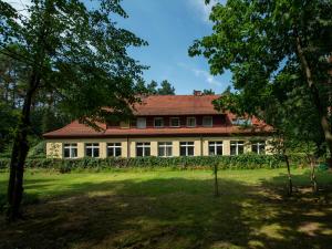 una gran casa blanca con techo rojo en Pasjonat Tu en Tuczno