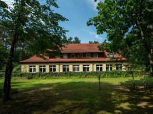 una gran casa blanca con techo rojo en Pasjonat Tu, en Tuczno