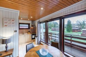cocina con mesa y ventana grande en Birch Lodge 14 with Hot Tub, en Newton Stewart 13 fotos más