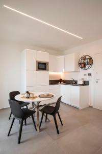 una cucina e una sala da pranzo con tavolo e sedie di Gentile 46 Blu Luxury Flat a Bari Altre 20 foto