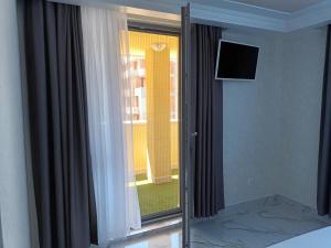 una camera con porta scorrevole in vetro e finestra di Apartament Milenium a Pomorie