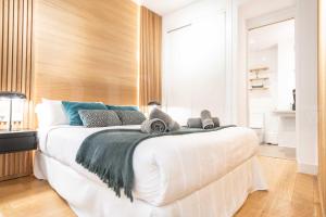 una camera da letto con un grande letto bianco con asciugamani di Elegant studio in the heart of Malaga by REMS a Málaga