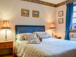 a bedroom with a bed with a tray of food on it at Toll Bridge Lodge in Banchory