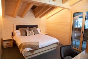 a bedroom with a bed in a wooden room at Chalet mit Kino und Jacuzzi in Gsteig b. Gstaad in Gsteig