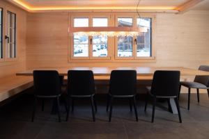 a dining room with a large wooden table and chairs at Chalet mit Kino und Jacuzzi in Gsteig b. Gstaad in Gsteig