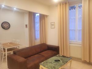 uma sala de estar com um sofá de couro castanho e uma mesa em L'ambassadeur - Colmar centre em Colmar