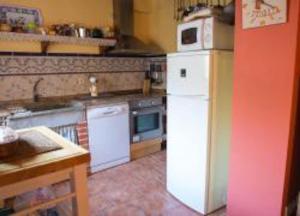 cocina con nevera blanca y fogones en Casa Rural Mi Rinconcillo, en Valleruela de Pedraza