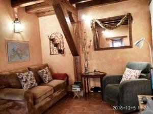 sala de estar con sofá y espejo en Casa Rural Mi Rinconcillo, en Valleruela de Pedraza