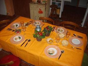einen Tisch mit einem gelben Tischtuch mit Tellern und Geschirr in der Unterkunft Casa Rural Mi Rinconcillo in Valleruela de Pedraza
