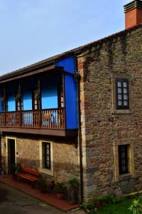 un edificio de ladrillo con balcón y banco en Casa Rural Casa Selmo, en Carreno