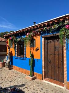 a blue and orange house with a door and flowers at Casa del Trotamundos in Villamayor de Campos