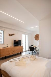 una camera bianca con un grande letto e una TV di Gentile 46 Blu Luxury Flat a Bari