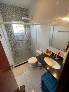 a bathroom with a toilet and a sink and a shower at Casa 4/4 com piscina. in Maricá