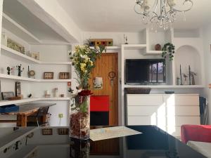 コルドバにあるTati flat - "Parking Fácil"の白いキャビネットと花瓶付きのテーブルが備わるキッチン