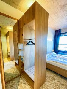 een slaapkamer met een bed en een grote houten muur bij Boulderbar Hotel Leonding in Linz