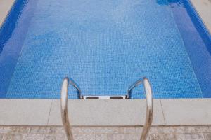 a swimming pool with two metal chairs next to it at Casa da Morena in Santa Cruz