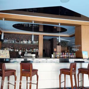 un bar con sedie e un bancone con bottiglie di liquore di Apartament Milenium a Pomorie