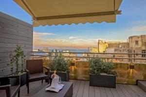 a balcony with chairs and a view of a city at The Capital Boutique Hotel in Valletta