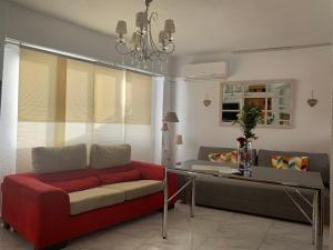 a living room with a red couch and a table at Tati flat - "Parking Fácil" in Córdoba