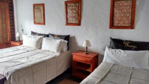 1 dormitorio con 2 camas y mesa con lámpara en Posada Agua Pampas en Villa Ventana