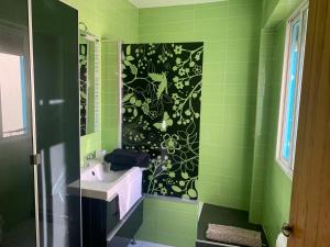 a green bathroom with a sink and a mirror at Tati flat - "Parking Fácil" in Córdoba