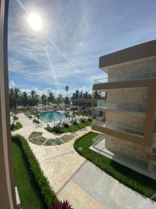 vista su un edificio con piscina e palme di Exclusivo apartamento frente al mar a San Pedro de Macorís