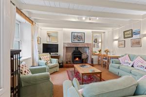 a living room with blue couches and a fireplace at Finest Retreats - Harbour House in Craster