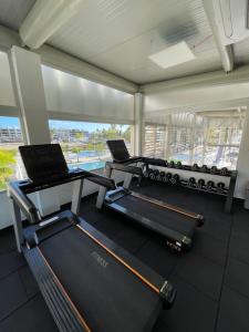 a gym with three treadmill machines and a window at Exclusivo apartamento frente al mar in San Pedro de Macorís