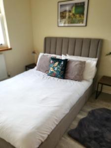 Una cama con sábanas blancas y almohadas en un dormitorio en Southcourt, en Worthing